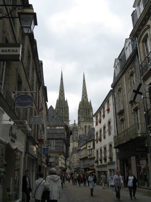 Street in Quimper with cathedral spires rising at the end.